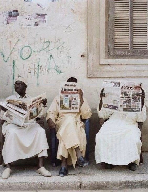 About Us - People reading newspapers on the street in emerging markets